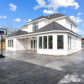 Baton Rouge Home Builder in backyard with concrete driveway and patio